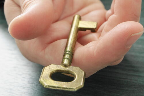 Den Schlüssel in der Hand halten